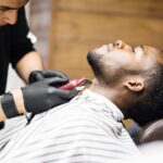 Barber shaving hair on client neck