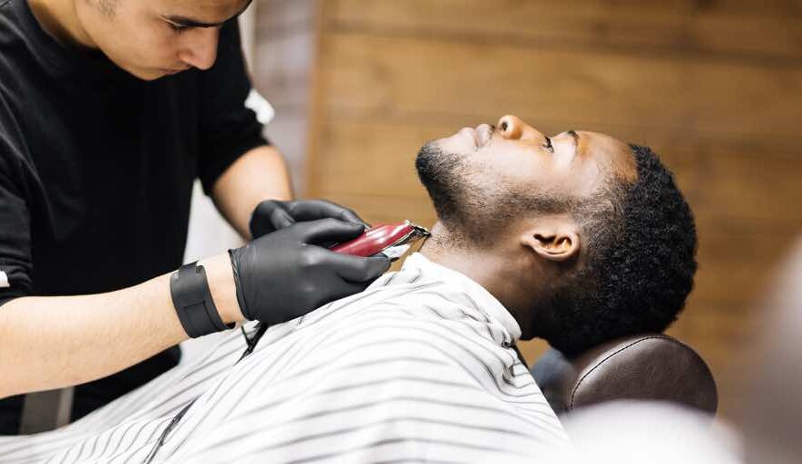 Barber shaving hair on client neck