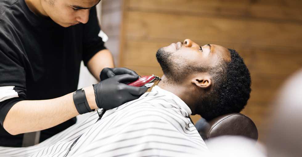 Barber shaving hair on client neck