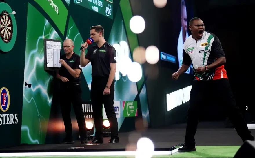 David Munyua fought back from two sets down to beat former World Grand Prix champion Mike de Decker at Alexandra Palace